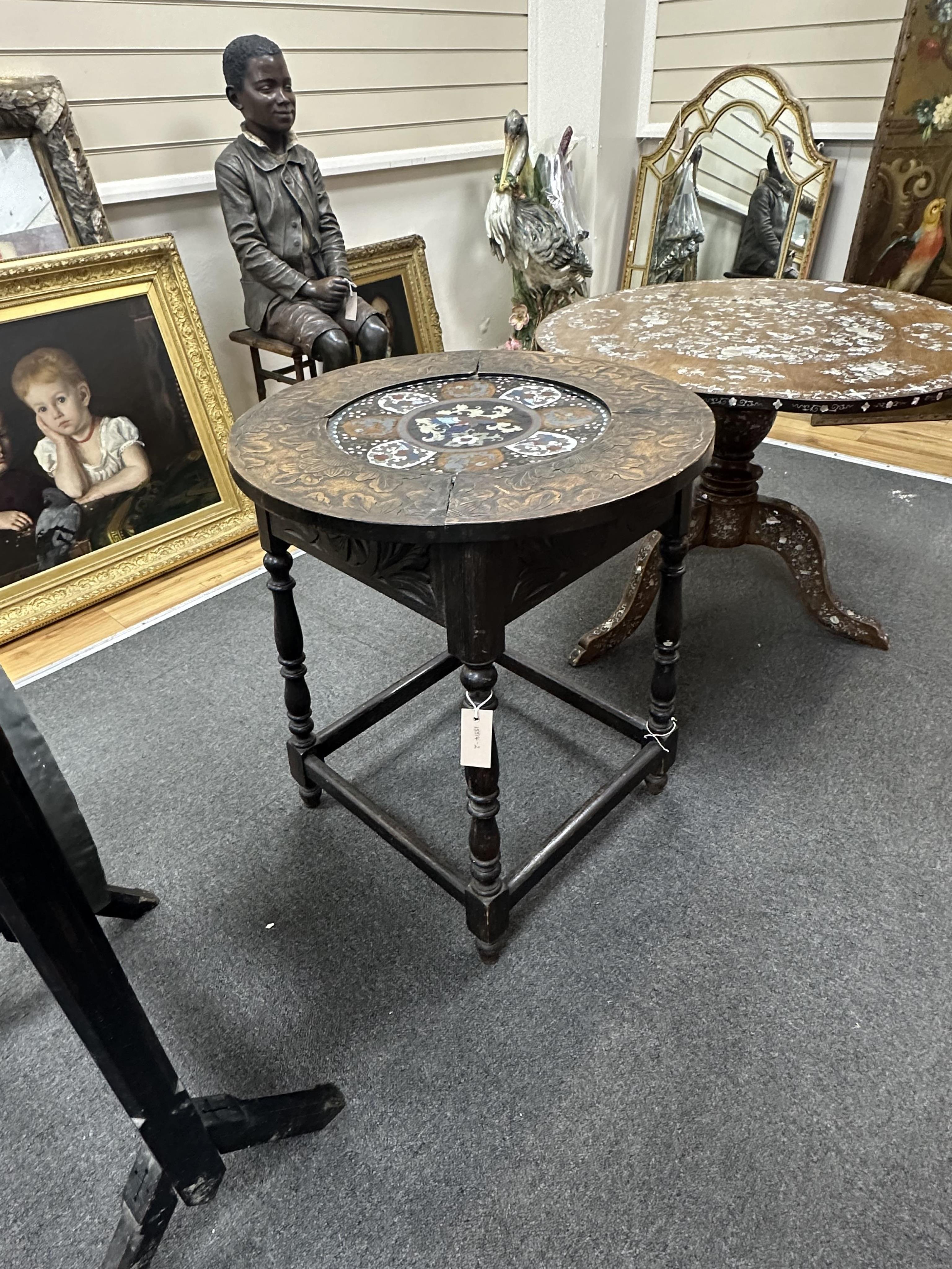 An early 20th century circular carved beech and cloisonne topped occasional table, on oak underframe, diameter 61cm, height 70cm. Condition - fair